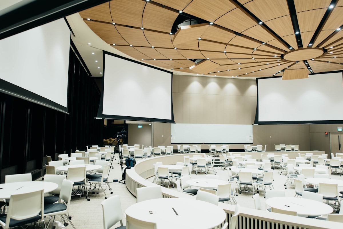 A large banquet hall with round tables and chairs set up for a nonprofit fundraiser dinner event